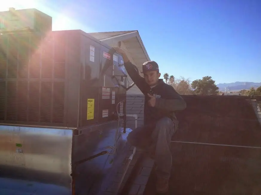 HVAC technician performing Air Duct Repair on a rooftop unit in West Dundee