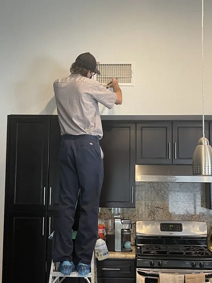 Technician inspecting an air vent during HVAC service in West Dundee